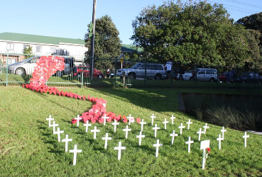 Crosses with a "river" of poppies climbing the fence